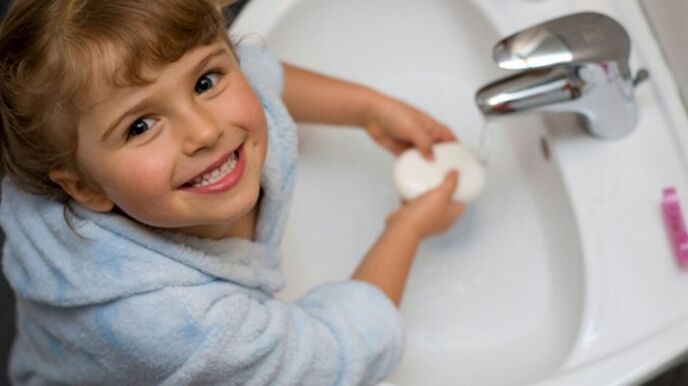 το παιδί πλένει τα χέρια του με σαπούνι για να αποτρέψει σκουλήκια
